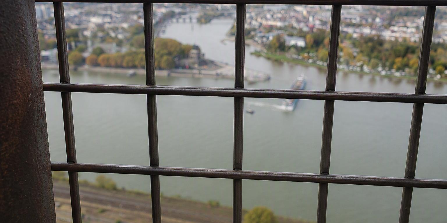 Vergittertes Fenster mit Blick aufs Deutsche Eck - Symbolbild-KI überarbeitet