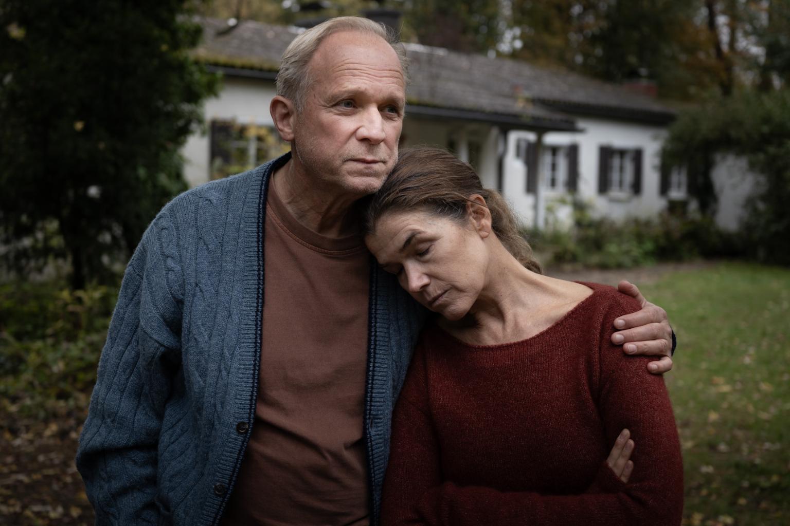 Rita (Anke Engelke) und Hans (Ulrich Tukur), ein in die Jahre gekommenes Ehepaar in vertrauter Umarmung.