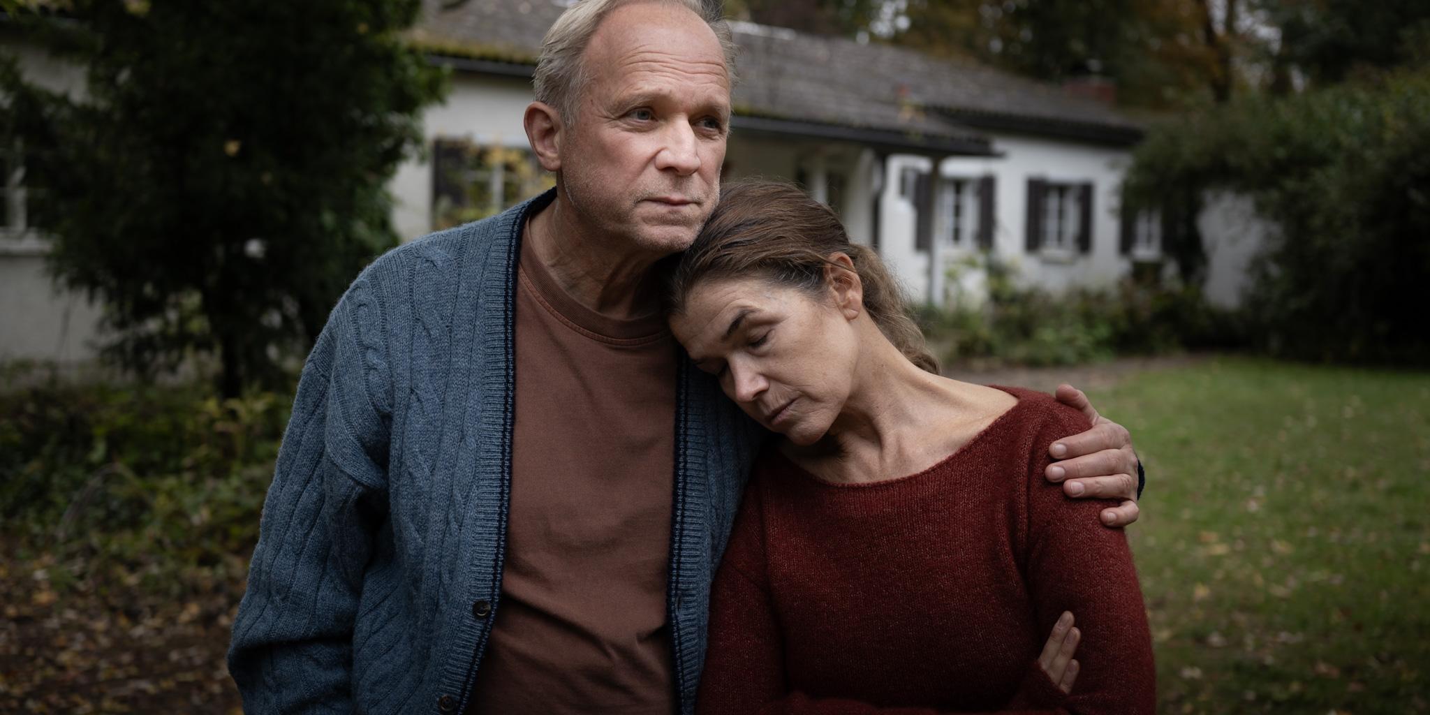 Rita (Anke Engelke) und Hans (Ulrich Tukur), ein in die Jahre gekommenes Ehepaar in vertrauter Umarmung.
