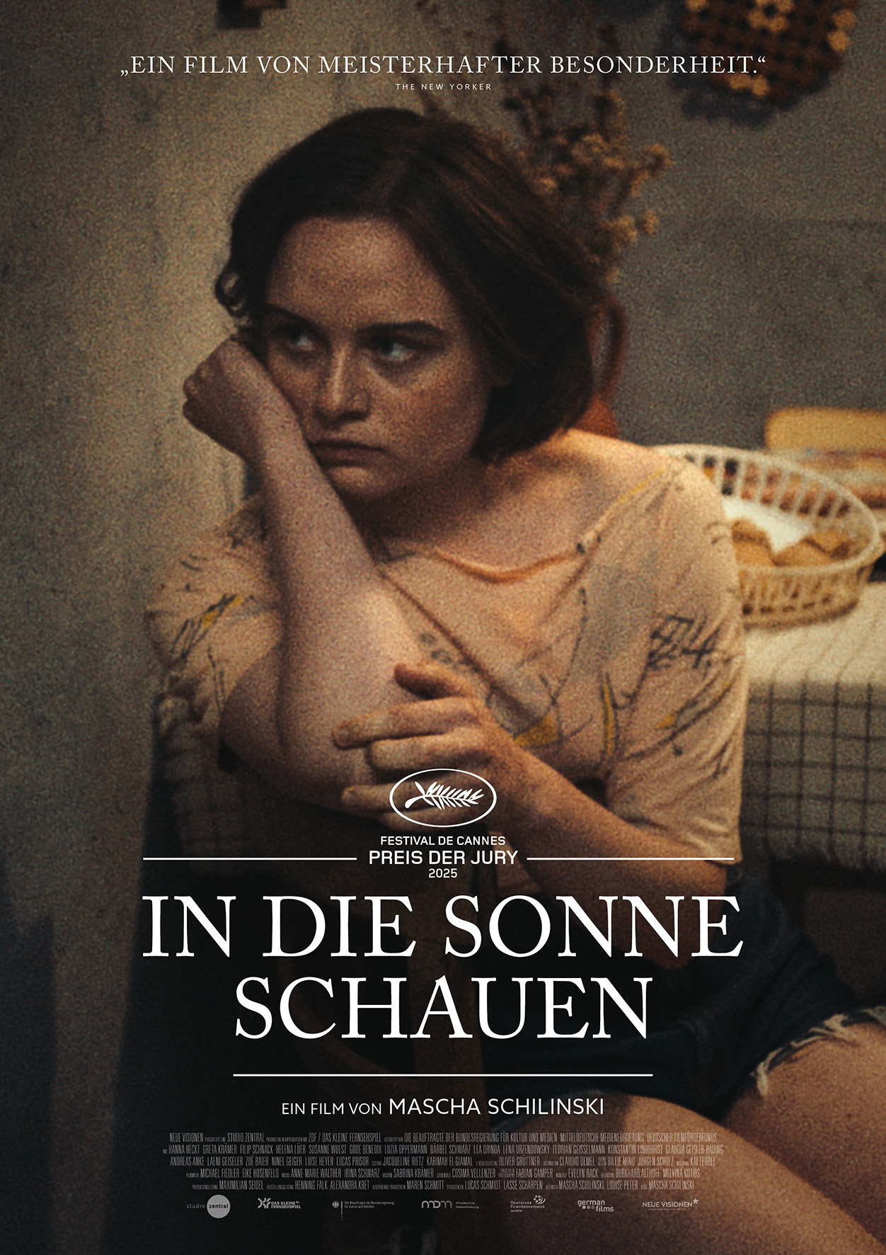 Filmplakat In die Sonne schauen - Frau sitzt mit auf den Arm gestützten Kopf nachdenklich auf einem Stuhl